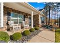 Inviting front porch with rocking chairs, decorative stone, and well-maintained landscaping at 460 Carrie Kathleen Ter, Carrollton, GA 30116