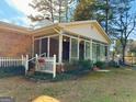 Exterior view of a sunroom addition to a brick home, featuring lots of windows and seamless transition to the backyard at 107 Cannongate Cir, Sharpsburg, GA 30277