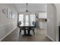 Open-concept dining area with stylish light fixture, view of the backyard, and a breakfast bar at 70 Willow Bend Nw Dr, Cartersville, GA 30121