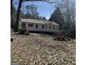 Exterior backyard view showcasing the back of the house with trees surrounding the property at 2256 Perkerson Mill Rd, Austell, GA 30106