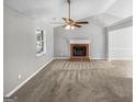 Living room featuring vaulted ceilings, a cozy fireplace, and neutral-toned carpet at 12 Bonnie Glen Ln, Hampton, GA 30228