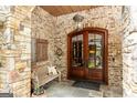 Charming entryway with stone accents, double doors, and a cozy bench, creating an inviting welcome at 4421 Paradise Cir, Vinings, GA 30339