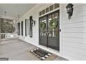 Elegant front door with glass panels, adorned with wreaths, and a charming welcome mat at 605 St. Charles Pl, Fayetteville, GA 30215