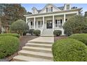 Inviting home featuring manicured landscaping, a porch, and a classic symmetrical facade at 605 St. Charles Pl, Fayetteville, GA 30215