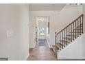 Bright foyer with wood floors, stairway, and white trim at 10459 Trellis Lane (Lot 27), Hampton, GA 30228