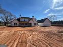 View of the rear of an unfinished single-Gathering home with covered patio and detached garage at 470 Snead Road # 1, Fayetteville, GA 30215