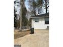 A view of the property's exterior, featuring durable siding, new windows, and a spacious concrete parking area at 5205 Kings Hwy, Douglasville, GA 30135