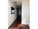 Hallway featuring hardwood floors and a large mirror, offering a welcoming entrance at 10467 Tara Beach Cir, Jonesboro, GA 30238