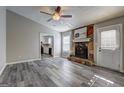 Inviting living room featuring a stone fireplace, ceiling fan, and stylish gray wood floors at 5495 Reynolds Rd, Morrow, GA 30260