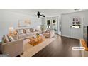 Bright staged living room with large bay window, elegant decor, and dark wood flooring at 11403 South Grove Dr, Hampton, GA 30228