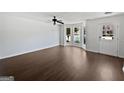 Spacious living room featuring dark wood flooring, a ceiling fan and a wall of bay windows at 11403 South Grove Dr, Hampton, GA 30228