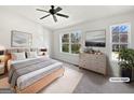 Staged main bedroom features a ceiling fan, large windows and decor at 11403 South Grove Dr, Hampton, GA 30228