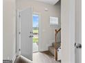 Welcoming foyer with hardwood floors, a staircase, and ample natural light streaming through the open doorway at 11192 Cornerstone Way, Hampton, GA 30228
