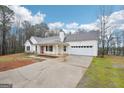Charming single-story home with white siding, red front door, covered porch and attached garage at 521 Cody Ln, Mcdonough, GA 30252