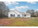 Charming single-story home featuring white siding, black shutters, attached garage, and spacious front yard at 521 Cody Ln, Mcdonough, GA 30252