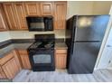 Well-equipped kitchen with black appliances, wood cabinets and neutral countertops at 3535 Waldrop Trl, Decatur, GA 30034