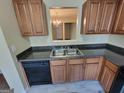 Modern kitchen with stainless steel sink, sleek black appliances, and wood cabinets at 3535 Waldrop Trl, Decatur, GA 30034