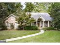 Traditional brick home featuring a well-maintained lawn and mature trees, creating an inviting entrance at 2275 Honeysuckle Se Ln, Smyrna, GA 30080