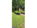 Spacious backyard featuring a grassy area surrounded by mature trees and foliage at 2317 Hillside Rd, Riverdale, GA 30296