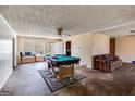 Spacious room with billiards table, fan, and a glimpse of the dining area and hallway at 2864 S 100 Hwy, Bowdon, GA 30108