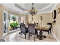 Elegant dining room with large windows, tray ceiling, chandelier, and traditional furnishings at 4335 Burgomeister Pl, Snellville, GA 30039