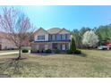 Attractive home with a lawn, mature trees, and a vibrant landscape at 4205 Lindsey Way, Conyers, GA 30013