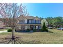 Beautiful two-story home with a manicured lawn and mature tree in a suburban setting at 4205 Lindsey Way, Conyers, GA 30013