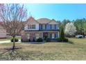 Inviting two-story home with a well-kept yard, trees, and blooming landscaping at 4205 Lindsey Way, Conyers, GA 30013
