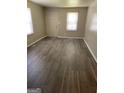 Bright living room features wood-look floors and a window for natural light at 3720 Asbury Sw Ln, Atlanta, GA 30331