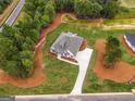 The aerial view of the home shows a beautiful property bordered by mature trees and carefully designed landscaping elements at 140 Paislee Park (Lot #5 Paislee Park) Dr, Fayetteville, GA 30215