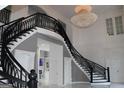 Stunning foyer with a sweeping staircase, intricate iron railings and dazzling chandelier at 337 Lakeshore Dr, Berkeley Lake, GA 30096