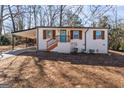 Charming white brick house boasts a carport, blue front door and wood shutters at 3650 Adkins Nw Rd, Atlanta, GA 30331