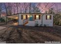 Charming white brick house boasts a carport, blue front door and wood shutters during twilight at 3650 Adkins Nw Rd, Atlanta, GA 30331
