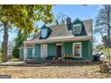 Exterior shot of a quaint two-story home with dormer windows and a covered front porch, offering curb appeal at 1444 Norman Berry Dr, East Point, GA 30344