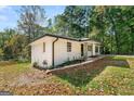 Angle view of a charming white brick home situated on a lot surrounded by mature trees at 256 Butterworth Rd, Canton, GA 30114