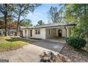 Angle view of a home showcasing a white brick exterior, covered carport, and mature trees at 256 Butterworth Rd, Canton, GA 30114