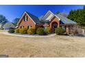 Beautiful brick home with manicured shrubs and a charming arched entryway, offering classic curb appeal at 140 Surrey Park Dr, Fayetteville, GA 30215