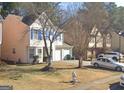 Traditional two-story home with a well-manicured lawn, showcasing charming curb appeal and an attached two-car garage at 775 Windemere Oak Nw Way, Lilburn, GA 30047