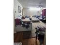 Cozy living room featuring plush sofas, neutral carpeting, and a ceiling fan for added comfort at 775 Windemere Oak Nw Way, Lilburn, GA 30047