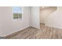 Bright bedroom featuring wood-look flooring and a large window, offering ample natural light at 8516 (Lot 130) Polston Place Dr, Douglasville, GA 30134