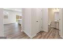 Hallway with wood-look floors, access to backyard, and a convenient half bathroom at 8516 (Lot 130) Polston Place Dr, Douglasville, GA 30134