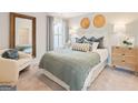 Bright bedroom features a cozy queen bed, a neutral color palette, and a comfortable armchair at 988 Sutherland Lane # 33, Lawrenceville, GA 30043