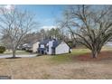 View of a two-story home with a gray roof, concrete driveway and well manicured lawn at 1015 Chapman Ln, Stone Mountain, GA 30088