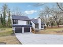 Two-story home featuring a gray roof, two car garage, concrete driveway and well manicured lawn at 1015 Chapman Ln, Stone Mountain, GA 30088