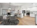 Open kitchen with white cabinets, stainless steel appliances, breakfast bar, and adjacent dining area at 1015 Chapman Ln, Stone Mountain, GA 30088