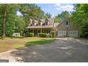 A charming home with attached garage and basketball hoop surrounded by beautiful green landscape with a long driveway at 9209 W Banks Mill Rd, Winston, GA 30187