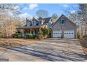 Traditional home with a large driveway, attached two-car garage, covered porch, and dormer windows at 9209 W Banks Mill Rd, Winston, GA 30187