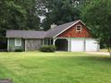 Home featuring a two-car garage, wood, and stone elements at 9091 Woodgreen Way, Jonesboro, GA 30238