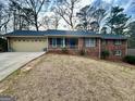 Brick home with a cozy front porch and a well-manicured front yard and attached garage at 365 Jordan Dr, Tucker, GA 30084