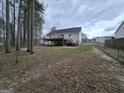 Backyard view featuring a large wooden deck with a fenced in yard and mature trees at 220 Joe Dr, Temple, GA 30179